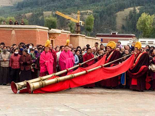 I monaci del monastero di Labrang suonano le lunghe trombe tibetane (dung chen) che hanno un suono simile a un muggito