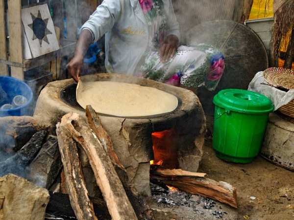 Cottura sul fuoco dell'impasto fatto con i minuscoli semi di teff per preparare l'injera, una specie di focaccia che è il cibo nazionale etiope
