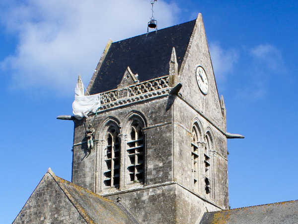 Sainte Mère Eglise - Ricordo del paracadutista John Steele che rimase appeso sul campanile della chiesa il giorno dello sbarco in Normandia
