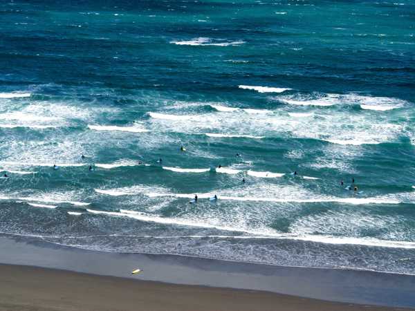 Surfers sulla spiaggia di Raglan