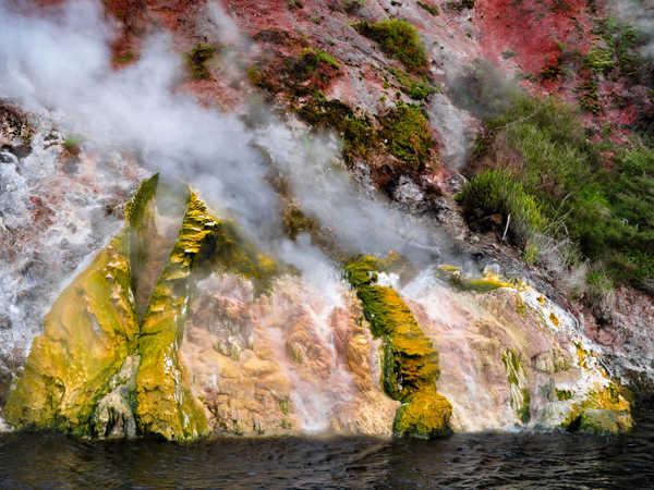 Waimangu Volcanic Valley - sbuffi di vapore fuoriescono tra le rocce variopinte che delimitano il lago detto 'frying pan' (la padella per friggere)